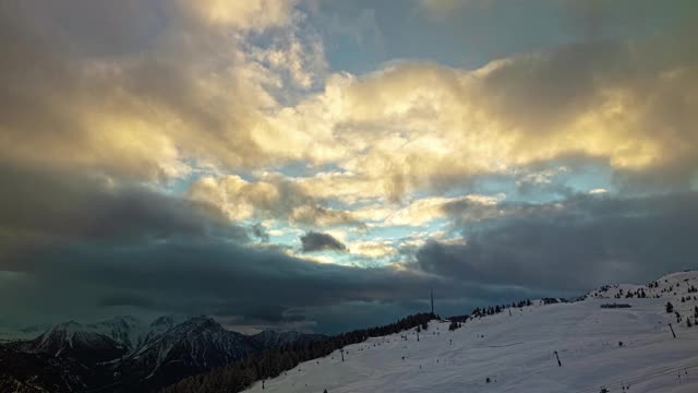 日落时，山上的云在跳舞。高山山坡全景。人们在瑞士阿尔卑斯山滑雪。Bettmeralp。广州Valais。视频素材