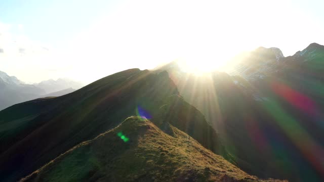 无人机拍摄的山顶与更大的山和太阳后面视频素材