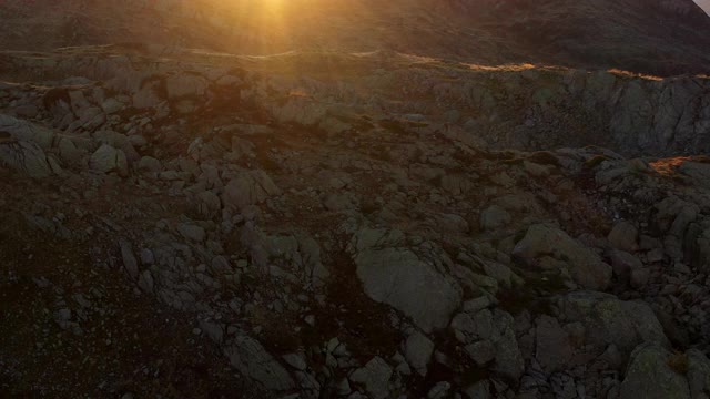 一架无人机拍摄的夕阳下的岩石山坡视频下载