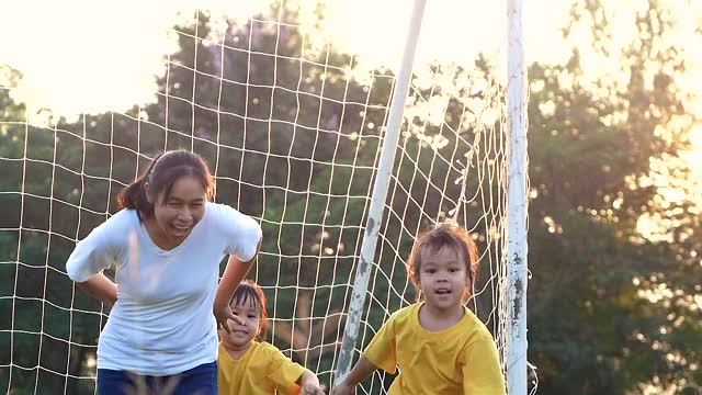 快乐的妈妈和她的女儿在夏天公园的草坪上玩耍和欢笑。全家人一起度假。视频素材