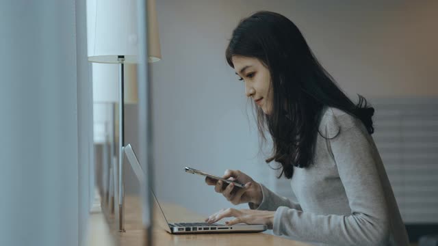 亚洲女学生在图书馆使用笔记本电脑视频素材