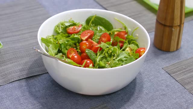 女人在厨房用勺子混合美味的超级食物沙拉原料视频素材