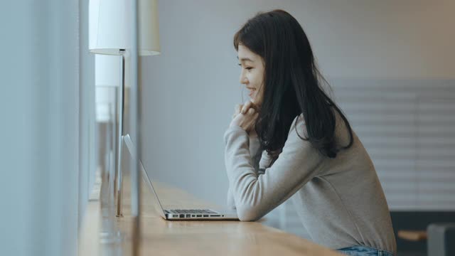 亚洲女学生在图书馆使用笔记本电脑视频素材