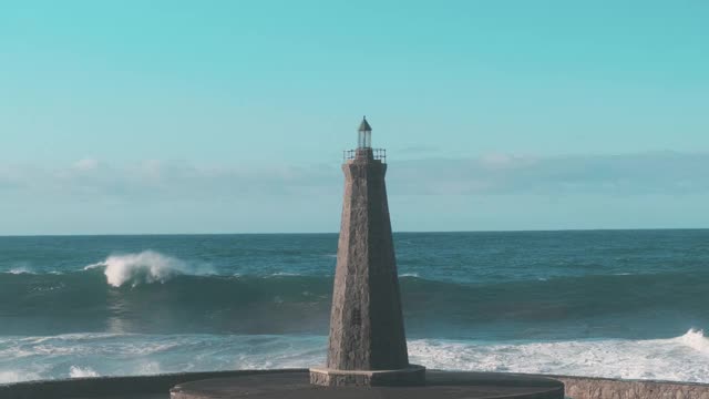 慢镜头:大海中，巨浪撞击着一座孤独的灯塔视频素材