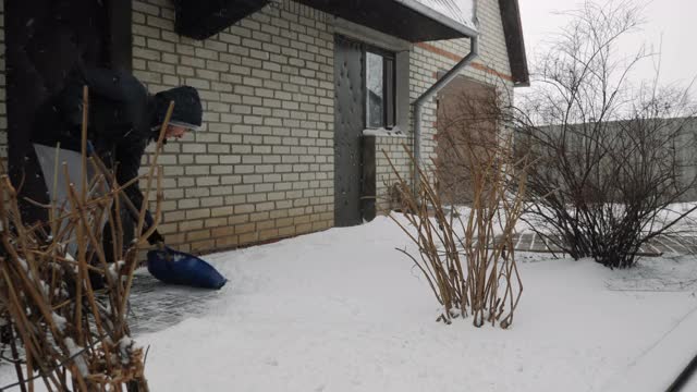 男性正在清扫道路上的积雪在冬天。人们正在铲路上的雪视频素材