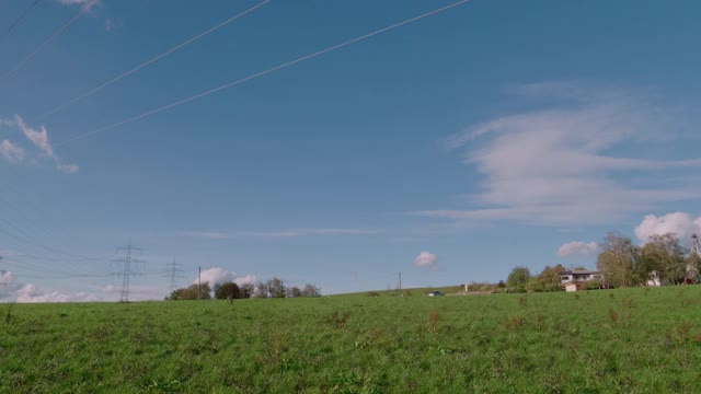 在乡村高速公路上，在滚动的田野上，有一排一排的电力塔视频素材