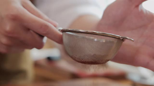 糕点师在做好的饼干上撒上巧克力粉。视频素材