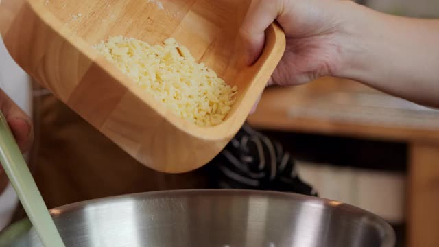 专家面包师在餐厅厨房的金属碗中加入白巧克力粉末的特写镜头。视频素材