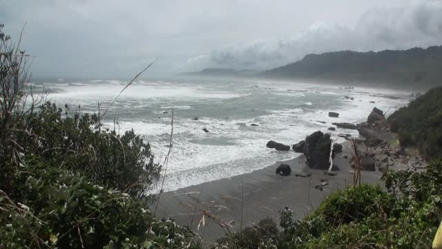 海浪在岩石海岸和山脉新西兰。视频素材