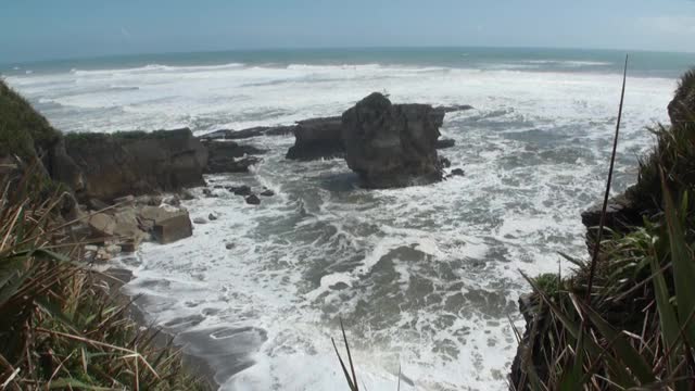 海浪的海景在地平线的背景，云在天空和岩石新西兰。视频素材