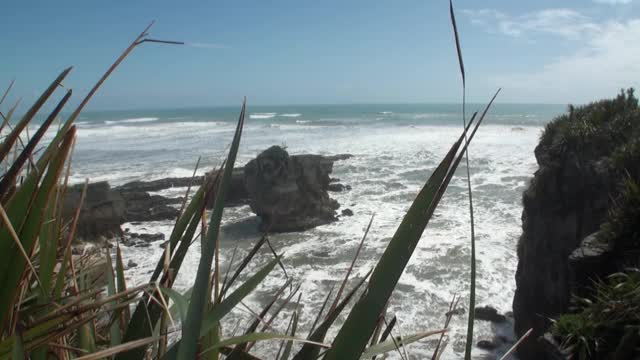 海浪在岩石海岸和山脉新西兰。视频素材