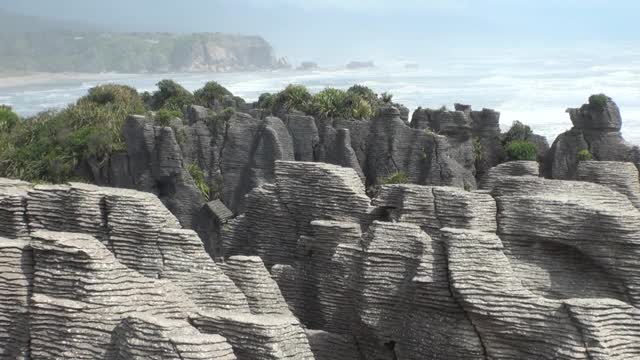 海浪在岩石海岸和山脉新西兰。视频素材