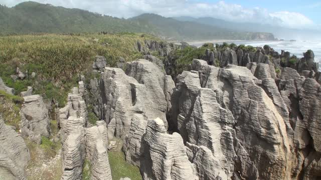 海浪在岩石海岸和山脉新西兰。视频素材