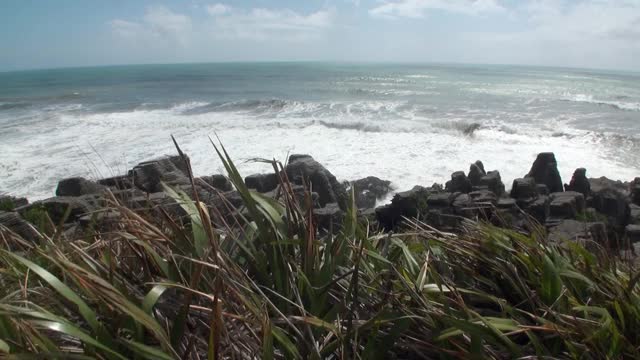 海浪在岩石海岸和山脉新西兰。视频素材