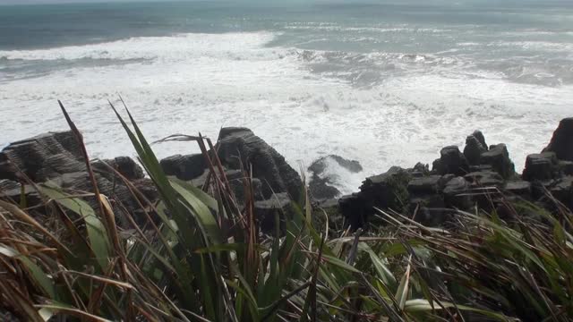 海浪在岩石海岸和山脉新西兰。视频素材