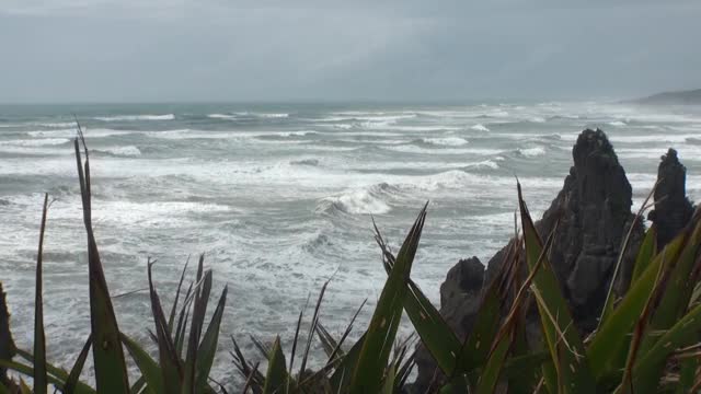 海浪在岩石海岸和山脉新西兰。视频素材