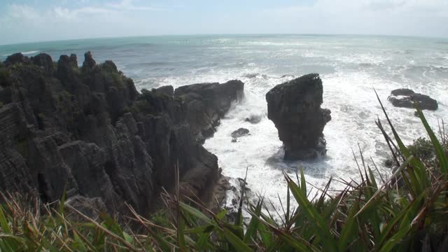 海浪在岩石海岸和山脉新西兰。视频素材