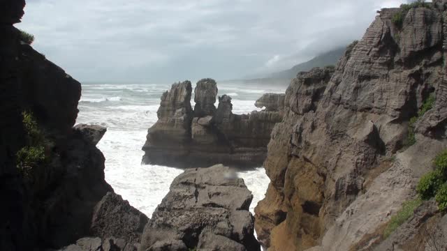 海浪在岩石海岸和山脉新西兰。视频素材