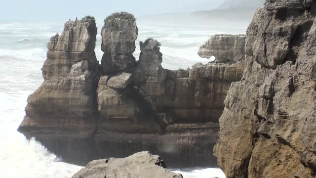 海浪在岩石海岸和山脉新西兰。视频素材