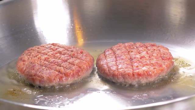 烤汉堡肉片或汉堡肉饼在煎锅上，特写视频素材