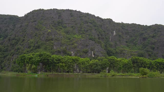 在越南北部的旅游胜地宁平山区，一艘船在岩石上观看。去越南旅游的概念视频素材