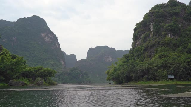 在越南北部的旅游胜地宁平山区，一艘船在岩石上观看。去越南旅游的概念视频素材