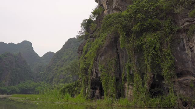 在越南北部的旅游胜地宁平山区，一艘船在岩石上观看。去越南旅游的概念视频素材