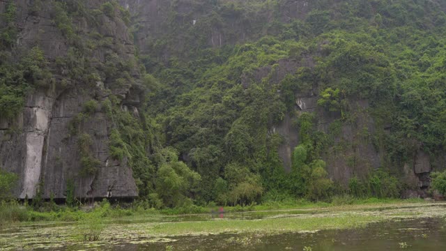 在越南北部的旅游胜地宁平山区，一艘船在岩石上观看。去越南旅游的概念视频素材