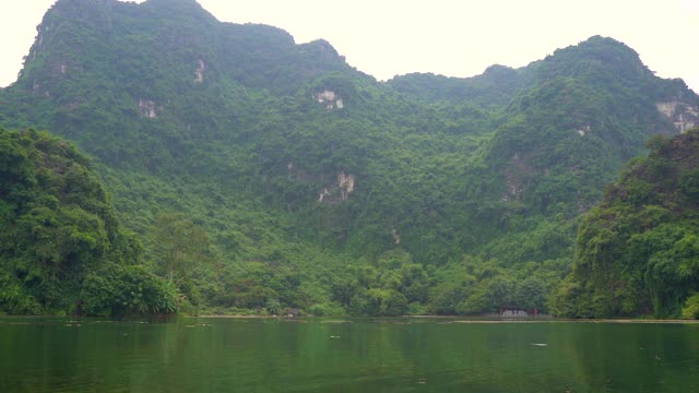 在越南北部的旅游胜地宁平山区，一艘船在岩石上观看。去越南旅游的概念视频素材