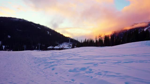 日落时分，白雪覆盖的地面和树木上空无一人的缆车升降椅视频下载