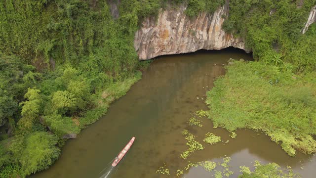 这是越南北部著名的旅游景点宁平地区美丽的石灰岩山脉的航拍照片。去越南旅游的概念。山洞的入口，由河流形成的穿过山的山洞的入口视频素材