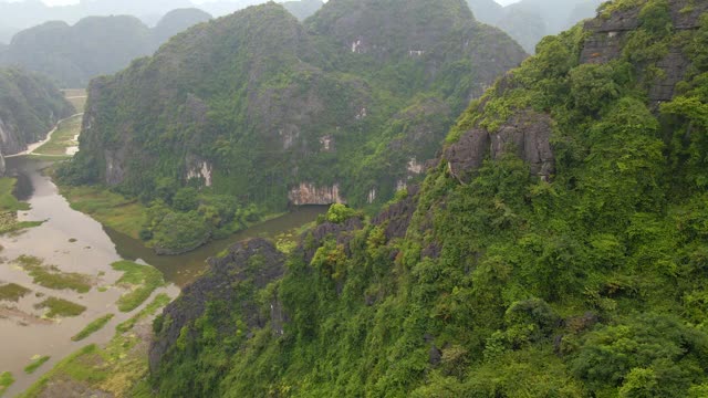 在越南北部的旅游目的地宁平，一名游客在大理石山，Mua洞山山顶的龙纪念碑上航拍。去越南旅游的概念视频素材