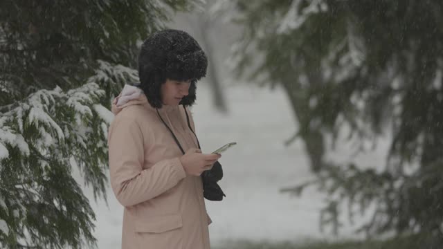 一个女人一边在下雪一边打电话视频素材