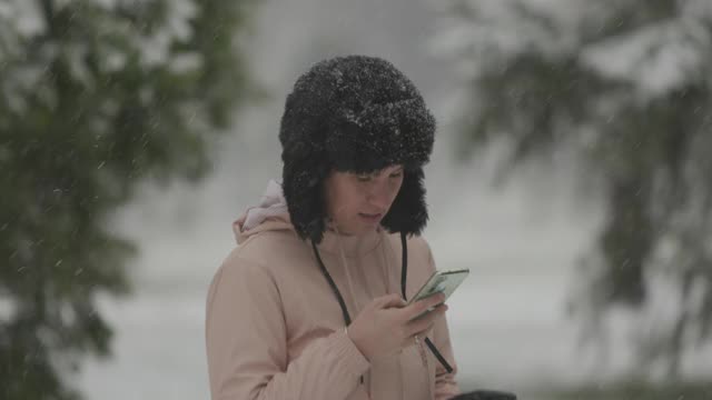 一个女人一边在下雪一边打电话视频素材