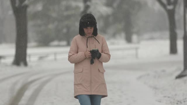 一个女人一边在下雪一边打电话视频素材