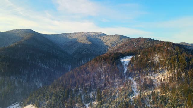 冬季日出的风景在冬天的山。山谷里的山上覆盖着白雪和薄雾视频素材