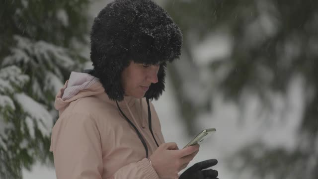 一个女人一边在下雪一边打电话视频素材