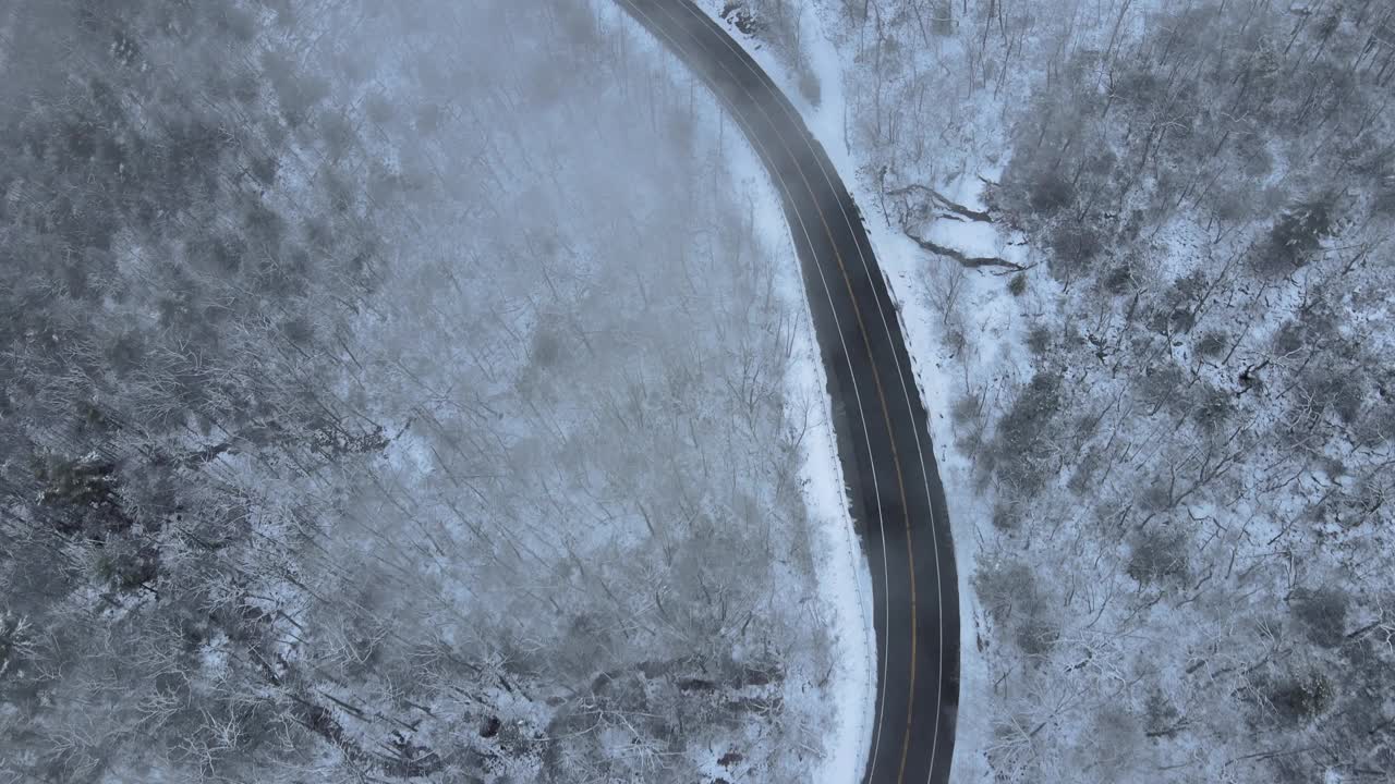 无人机拍摄的雪山高速公路上穿越云层的画面视频素材