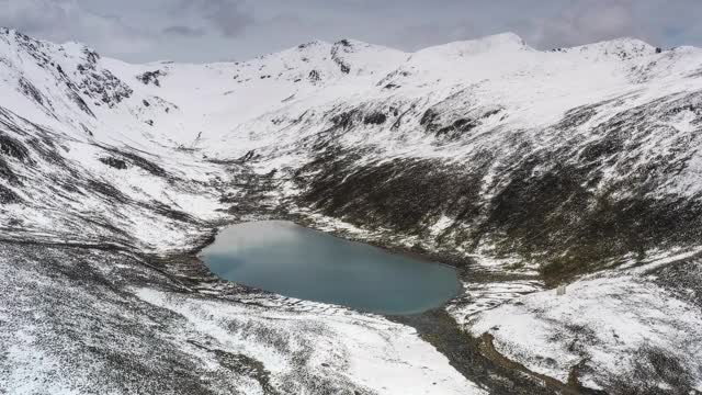 一个湖隐藏在雪山峡谷里视频素材