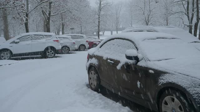 近距离观察:停在繁忙停车场的汽车被新的粉末雪覆盖。视频素材