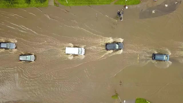 交通车辆在被雨水淹没的道路上行驶的鸟瞰图。视频素材