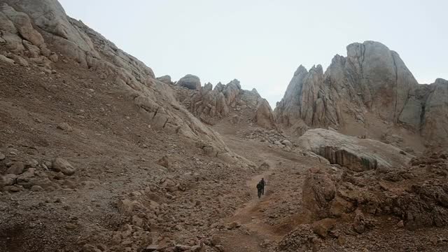 旅行的生活方式。生存的概念。徒步旅行者在一个下雨的大雾天走在山上的小径，背景。岩石、山。体育运动。视频素材