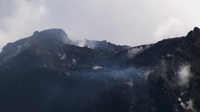 从哥斯达黎加阿雷纳尔火山顶部滚落的云和蒸汽的鸟瞰图。视频素材