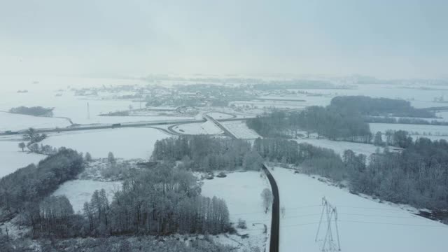 黑色柏油路之间的雪林从鸟瞰视频素材