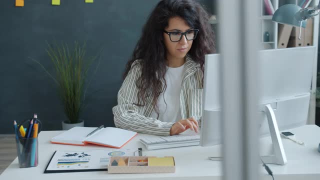 慢动作的漂亮的混血女孩使用电脑打字在现代办公室视频素材