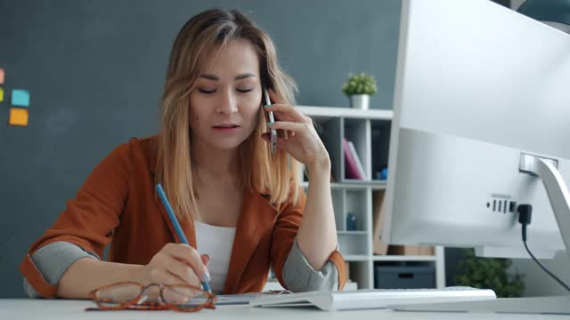 一位不开心的女商人正在和一位在办公室打电话的商业伙伴讨论一个问题视频素材