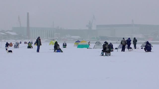 许多渔夫在结冰的水面上捕鱼。视频素材