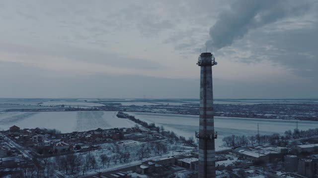 鸟瞰图的烟从锅炉管道的工业设施在一个下雪的冬天。视频素材