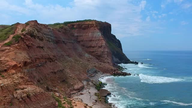 海浪撞击海滩岩石的鸟瞰图。葡萄牙海岸线上令人惊叹的悬崖海景。无人驾驶飞机。视频素材