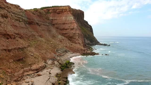 海浪撞击海滩岩石的鸟瞰图。葡萄牙海岸线上令人惊叹的悬崖海景。无人驾驶飞机。视频素材